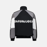 Back of a grey Windbreaker Jacket with black and white panels and INTERLUDE written in white