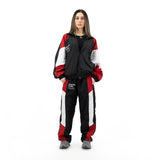 Woman wearing black, red, and white tracksuit with black shirt and gold necklace