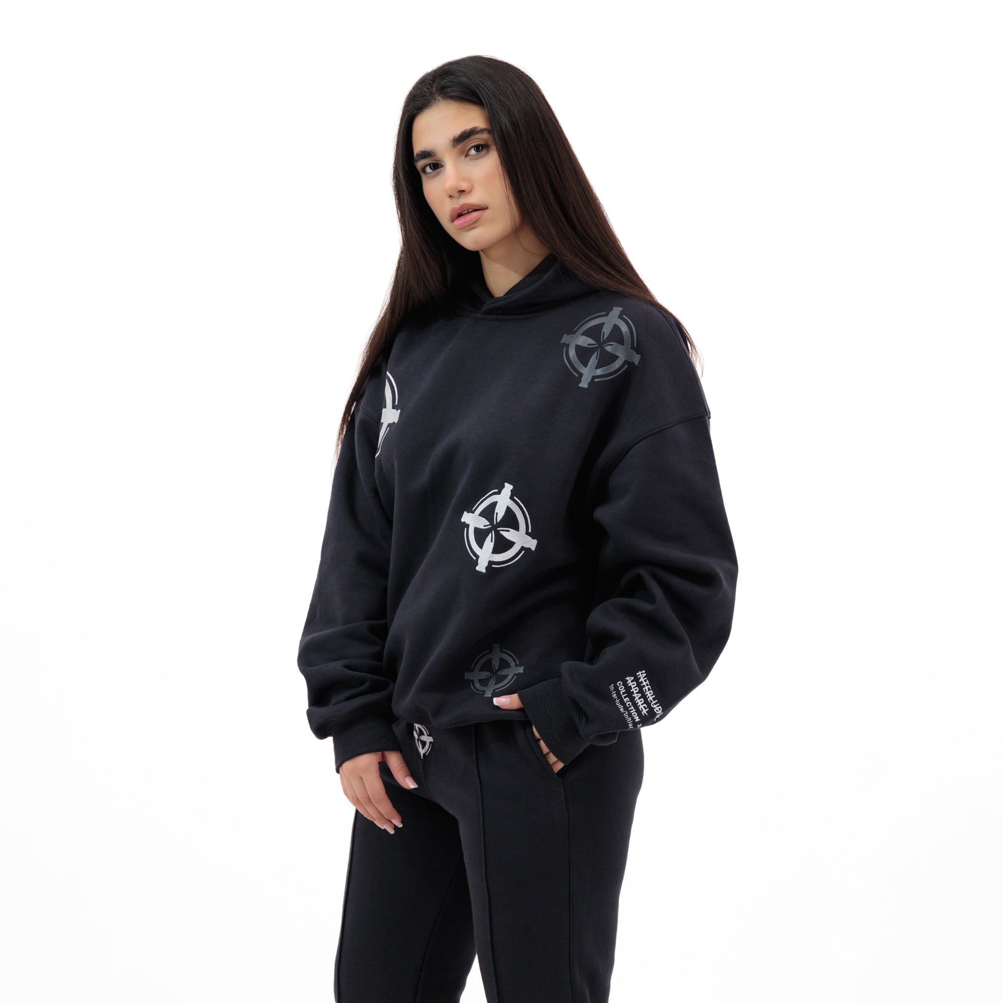 Woman wearing a black hoodie and sweatpants with a circular bullet design
