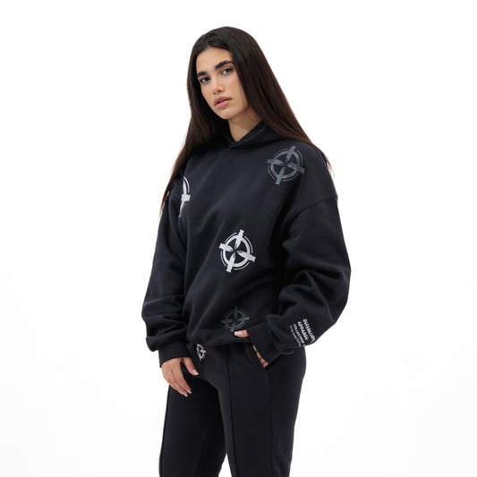 Woman wearing a black hoodie and sweatpants with a circular bullet design
