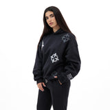 Woman wearing a black hoodie and sweatpants with a circular bullet design