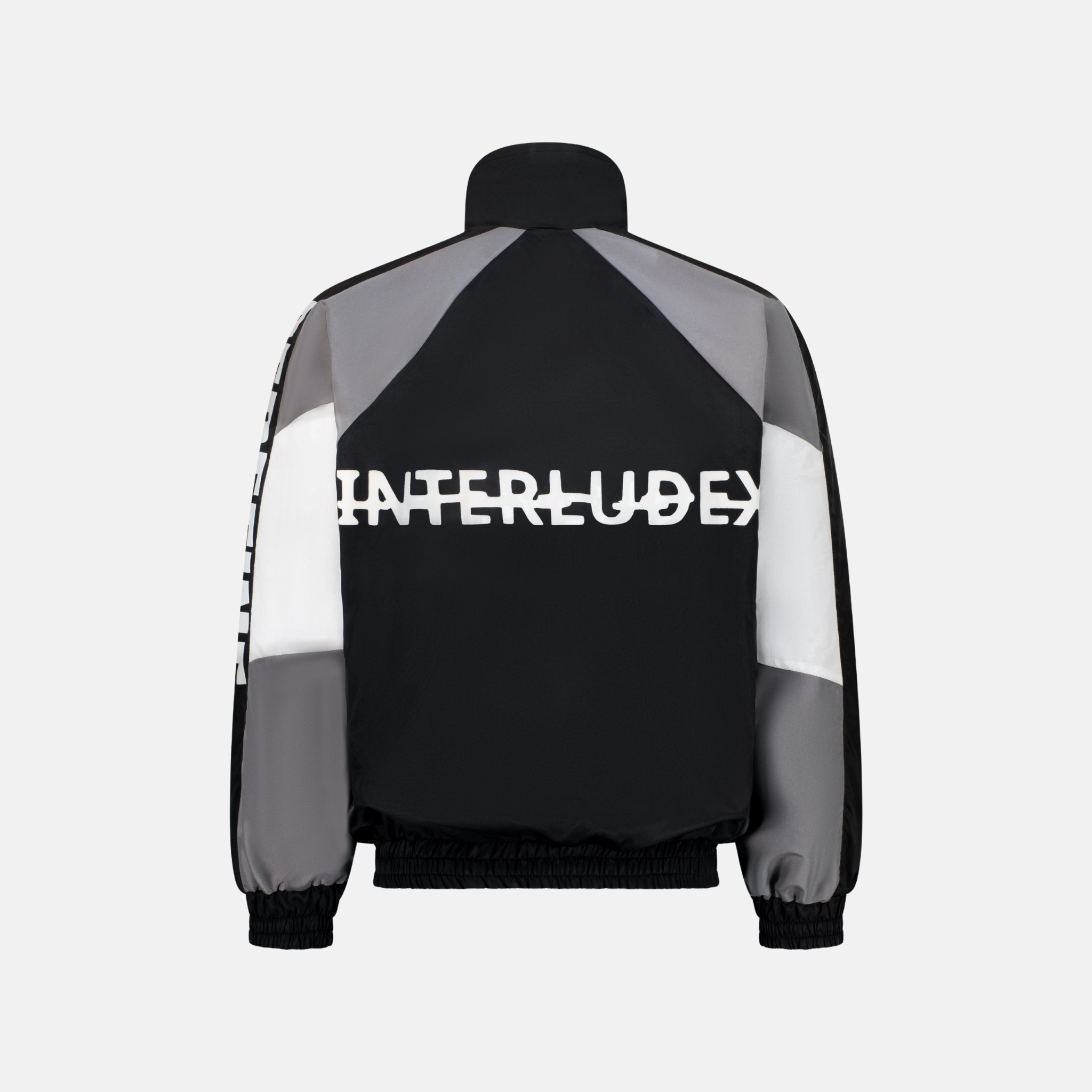 Back of a grey Windbreaker Jacket with black and white panels and INTERLUDE written in white